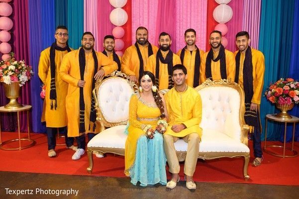 A large group of people are posing for a picture in front of a colorful backdrop.