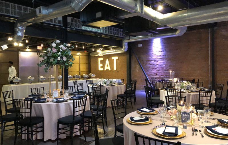 A large room filled with tables and chairs and a sign that says eat.