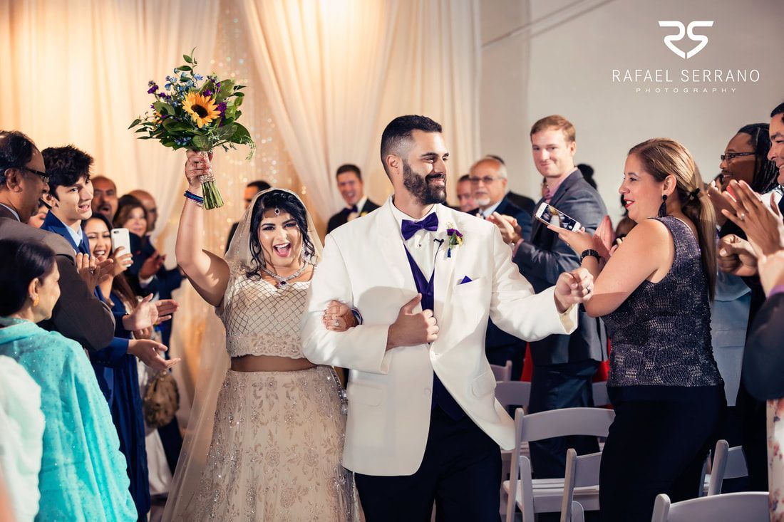 A bride and groom are walking down the aisle at their wedding