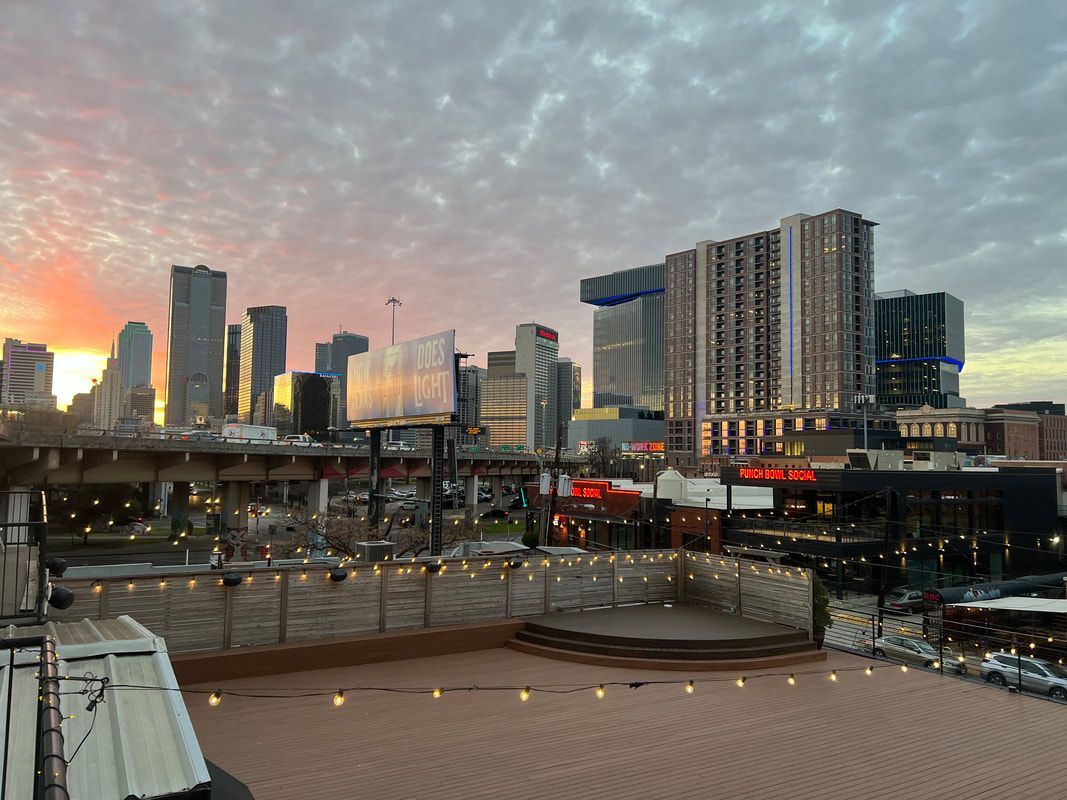 A view of a city skyline at sunset from a rooftop.