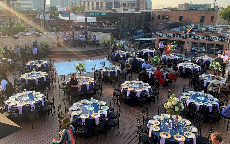 There are a lot of tables and chairs set up for a party.