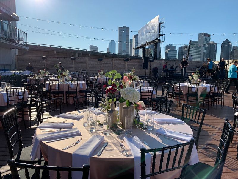 A rooftop patio with tables and chairs set up for a wedding reception.