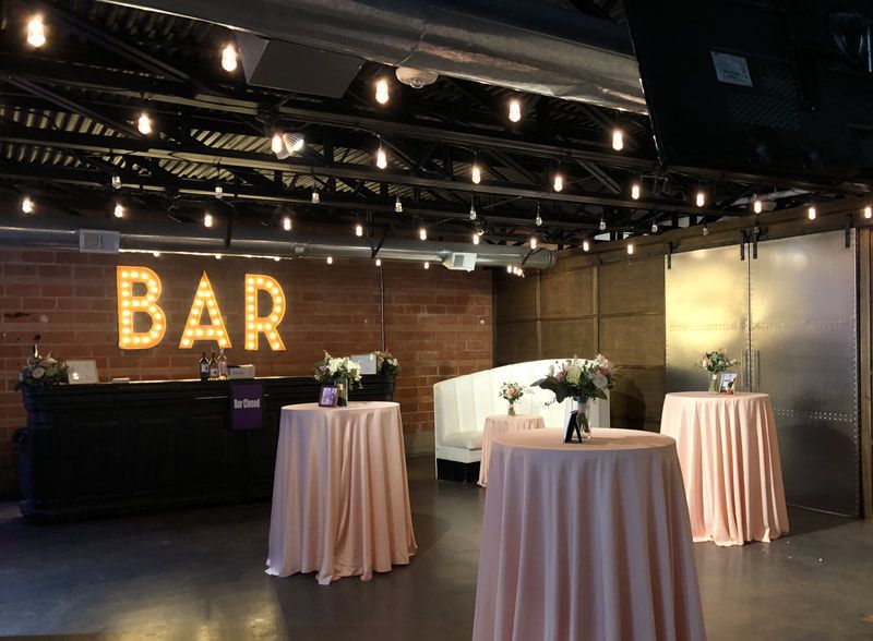 A room with tables and a sign that says bar.