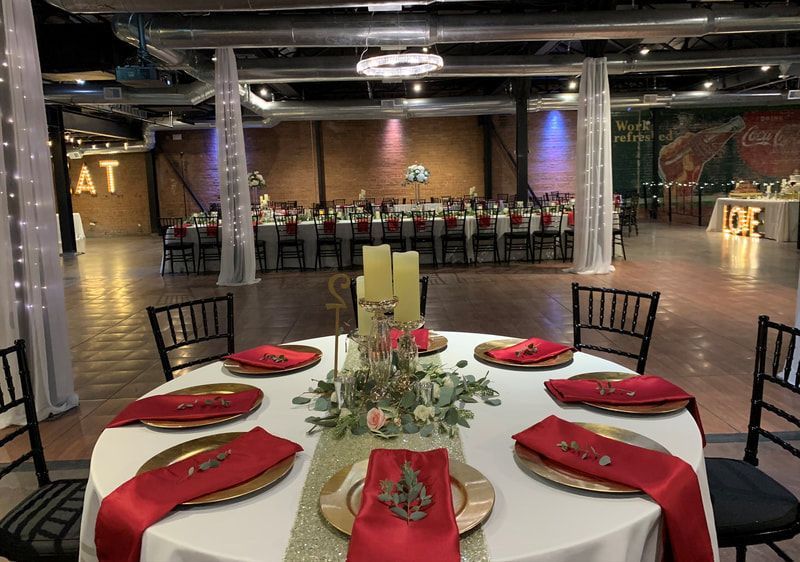 A large room with tables and chairs set up for a wedding reception.