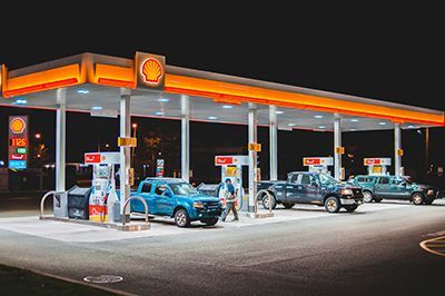 Shell gas station at night with trucks fueling.