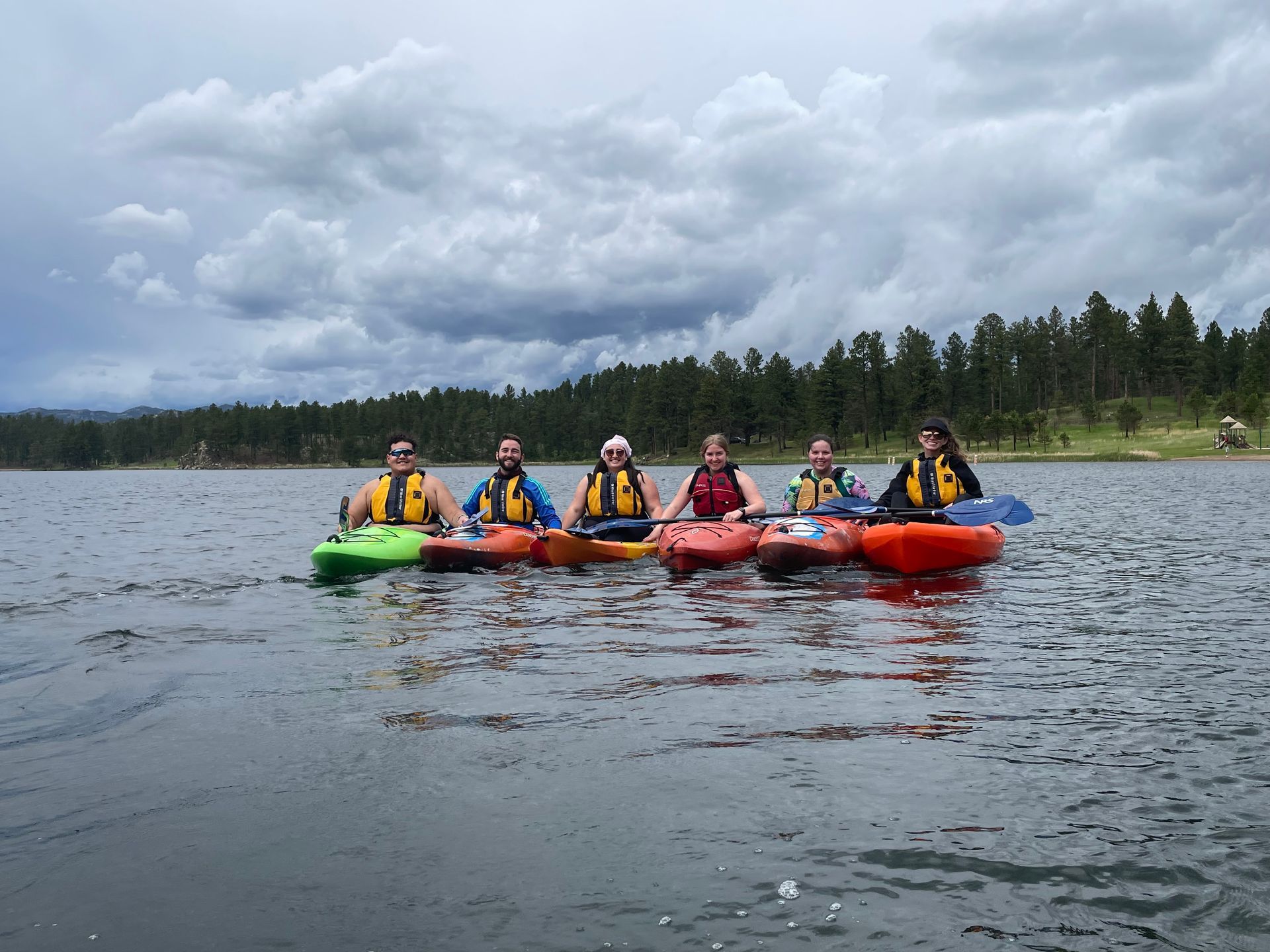 A group of people are in kayaks on a lake