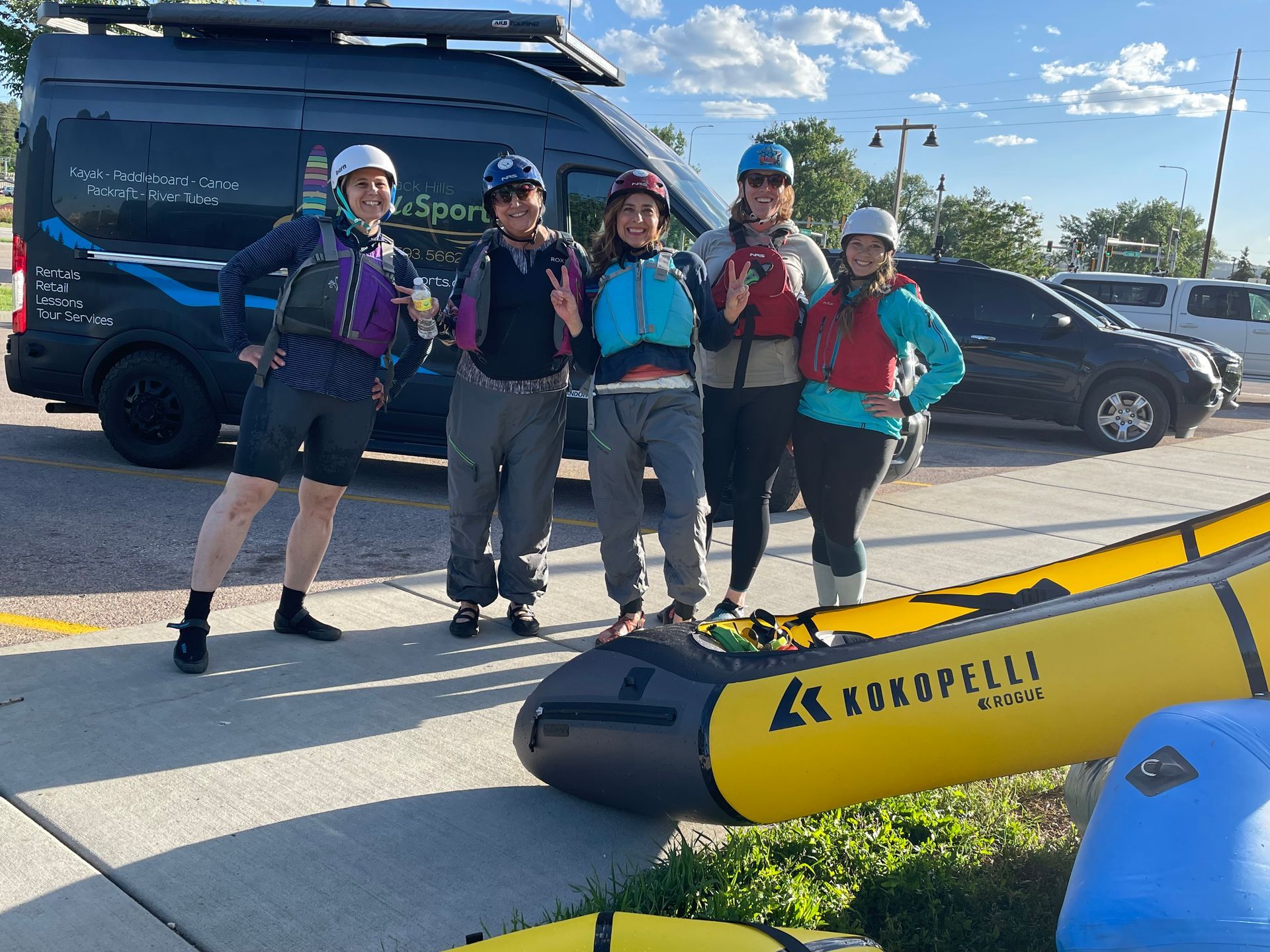 A group of people standing next to a yellow raft.