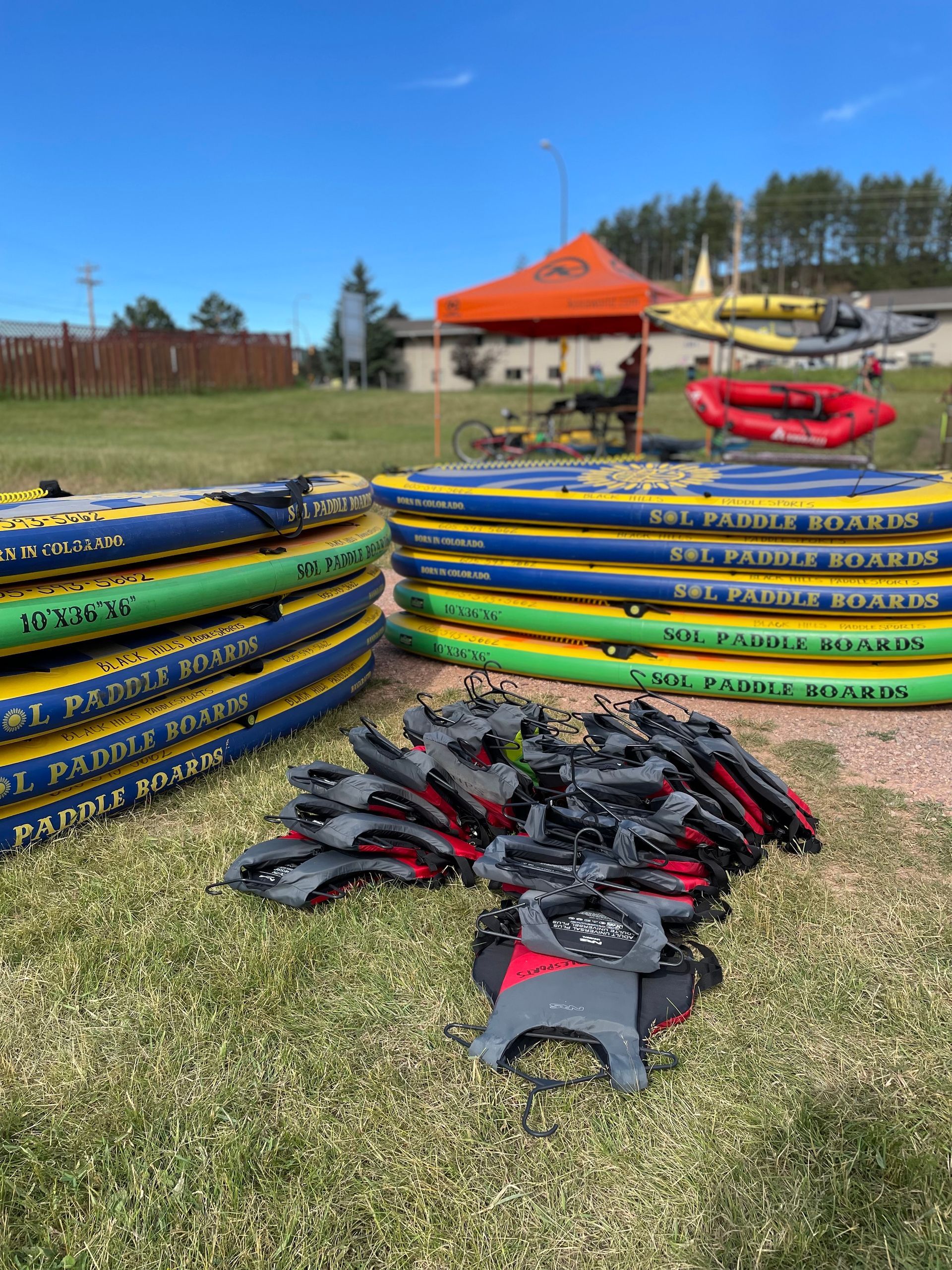 A bunch of rafts are stacked on top of each other in a field.