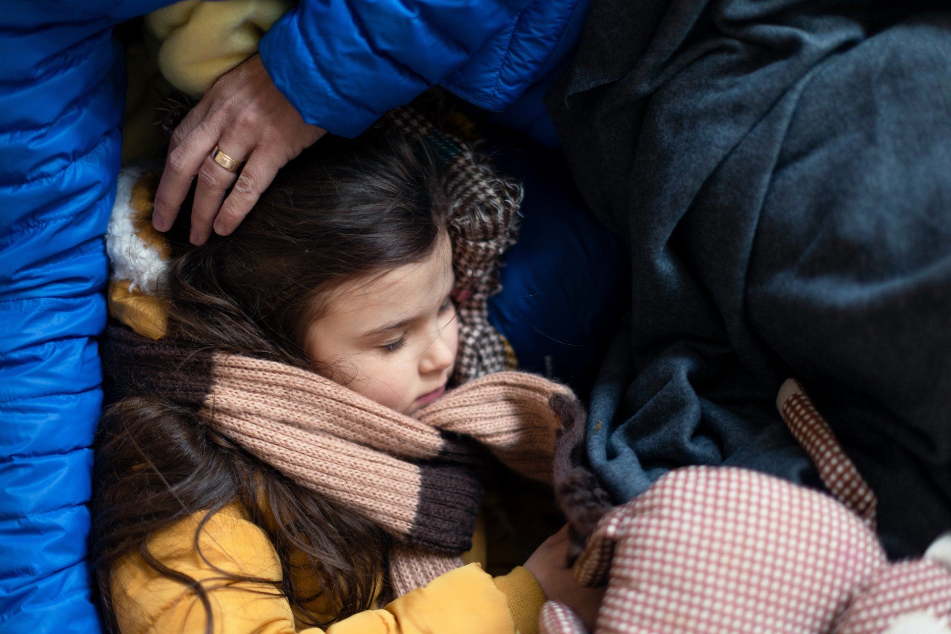 Refugiados de guerra ucranianos en refugio temporal y centro de ayuda niña durmiendo en el regazo de su madre