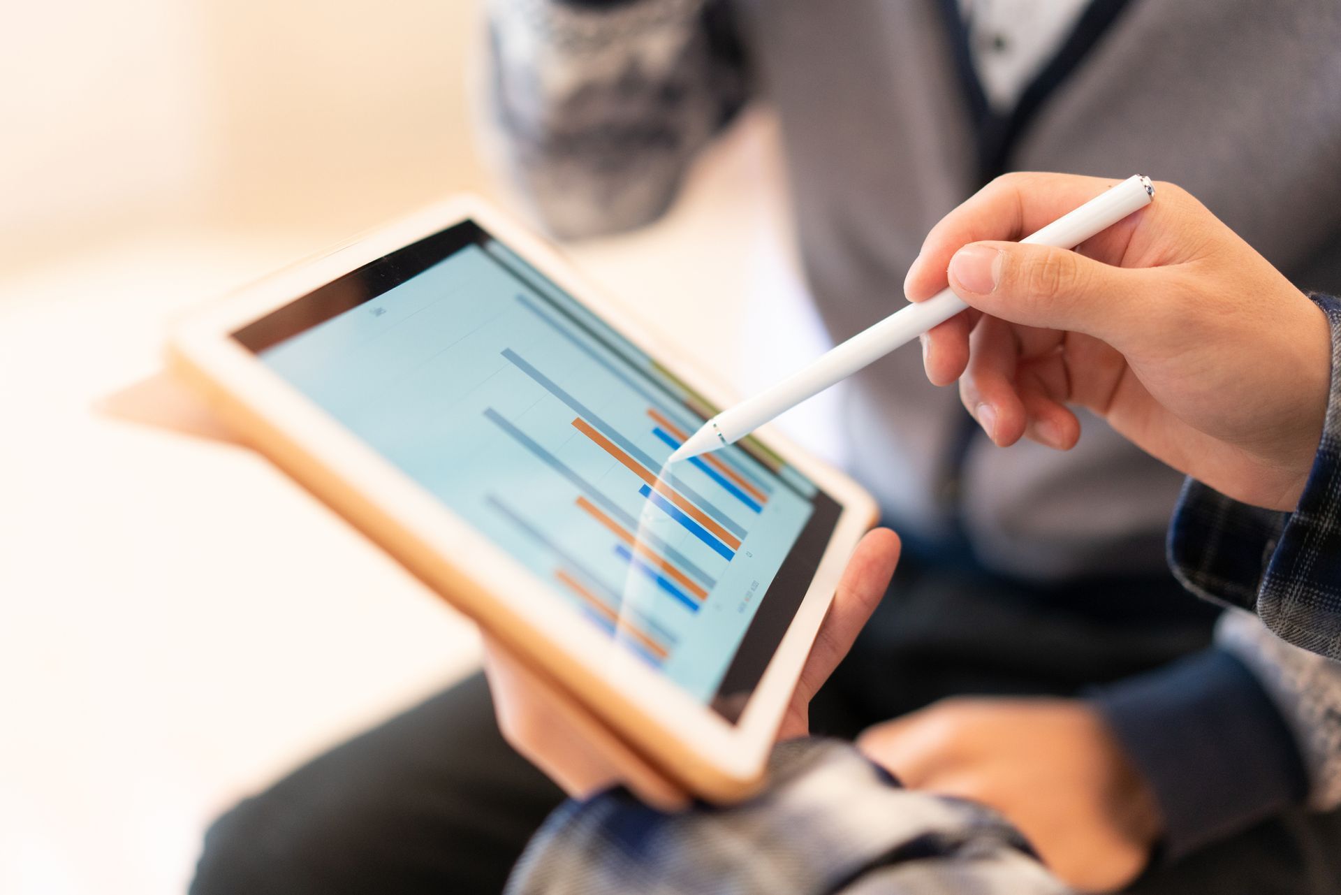 A person is using a pen to write on a tablet.