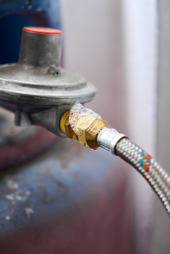 A statue of a mosaic head is sitting on a wooden stump.