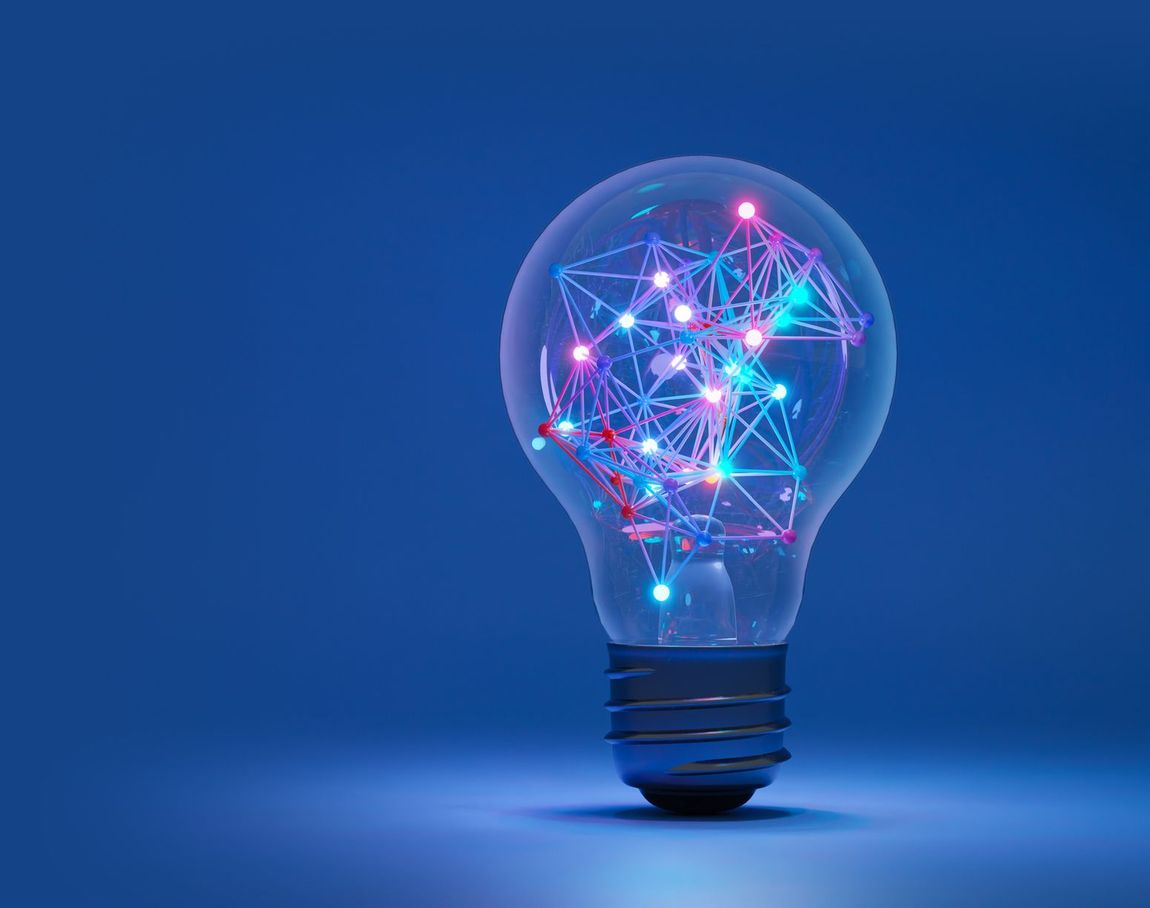 A light bulb with colorful lights inside of it on a blue background.