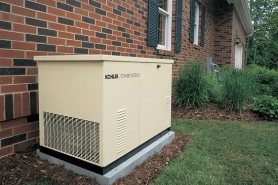 A generator is sitting on the side of a brick house.