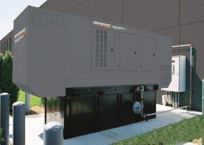 A large black generator is sitting in front of a building.