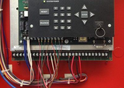 A close up of a control panel with wires coming out of it