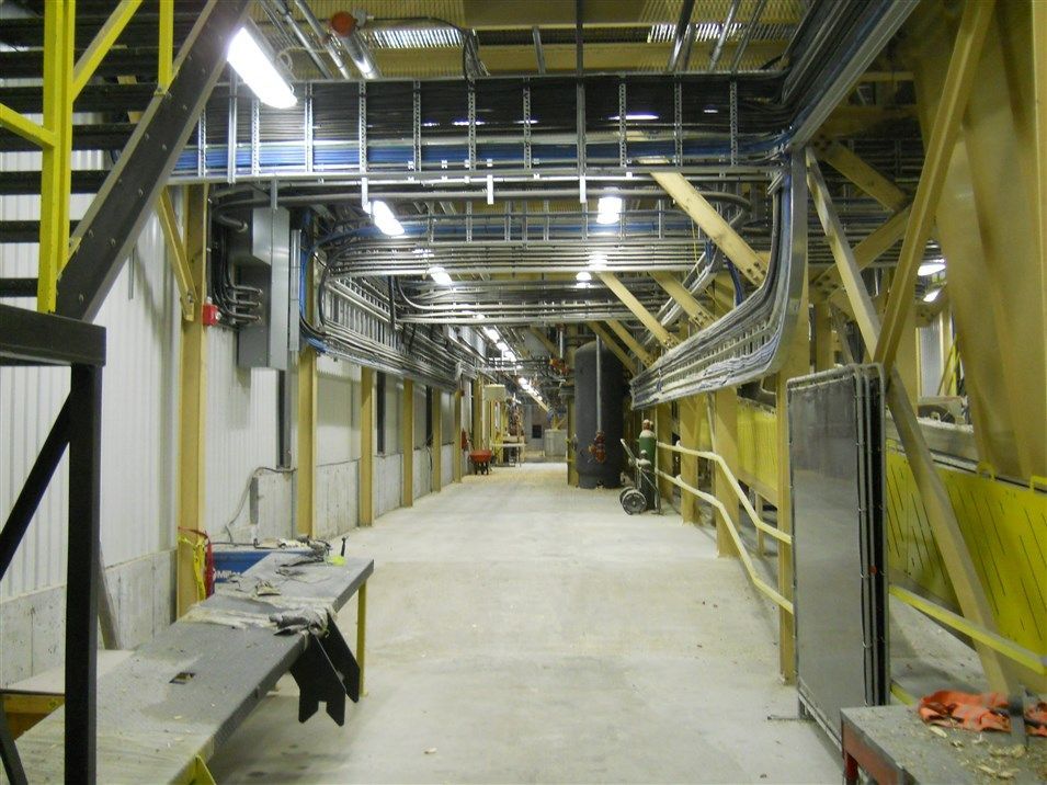 A long hallway in a building with a table and stairs