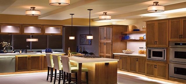 A kitchen with wooden cabinets , stainless steel appliances and a large island.