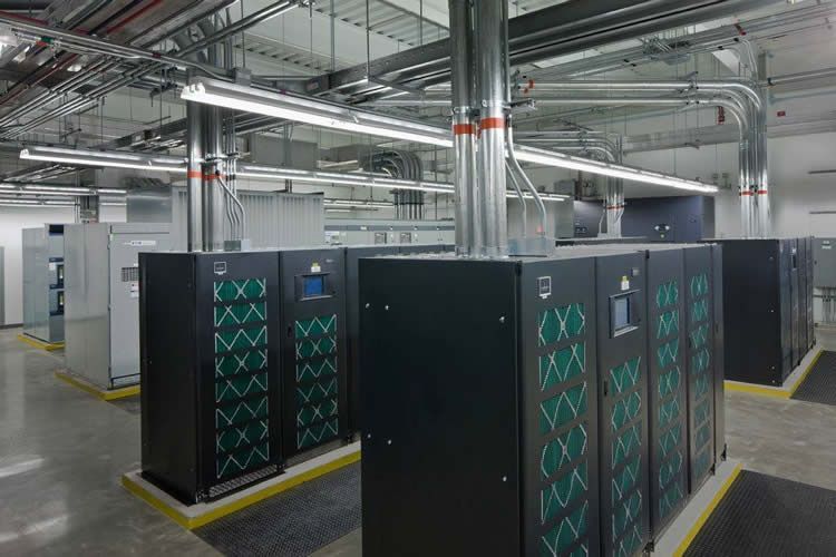 A row of servers are lined up in a large room.