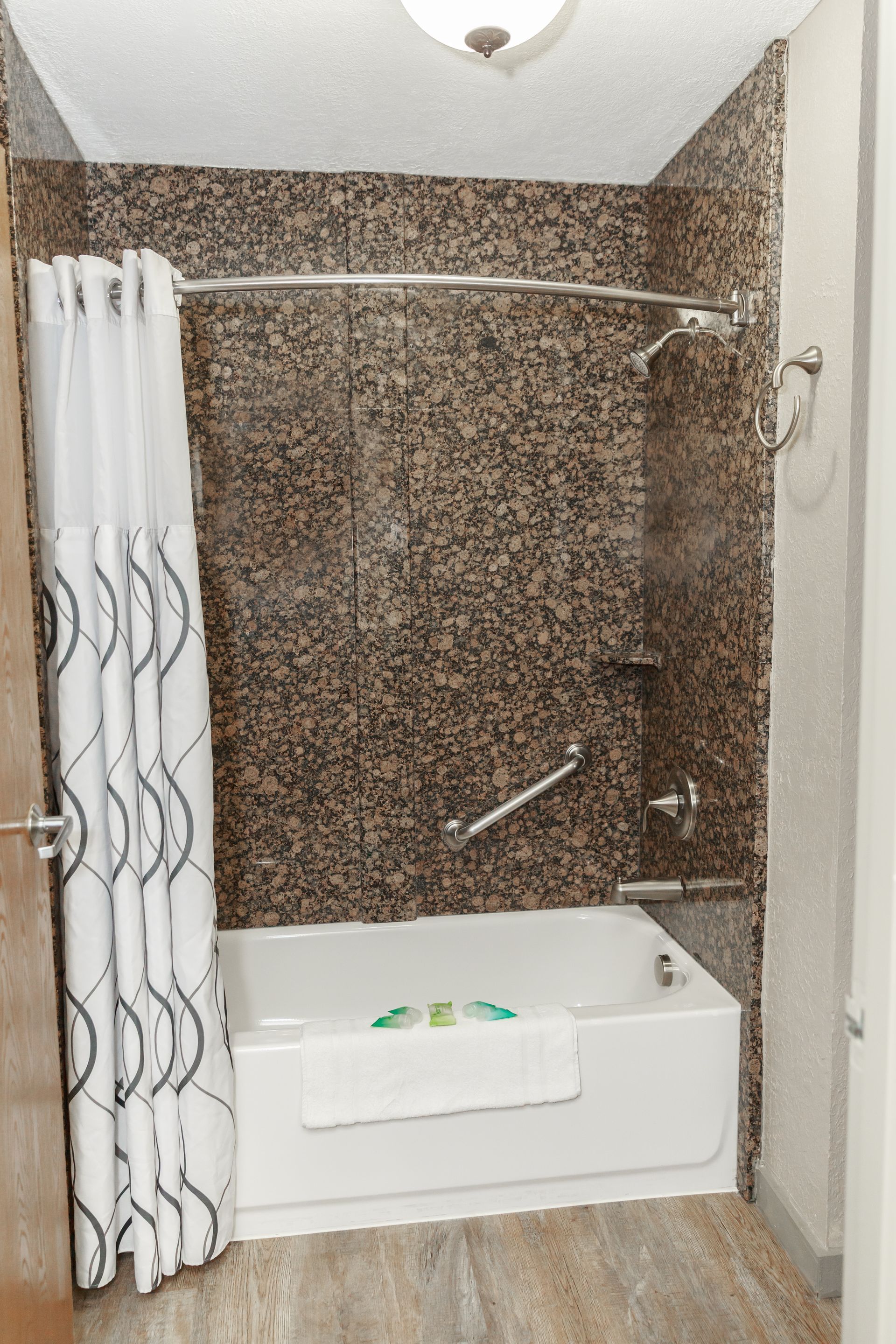 A bathroom with a tub and shower with a shower curtain.