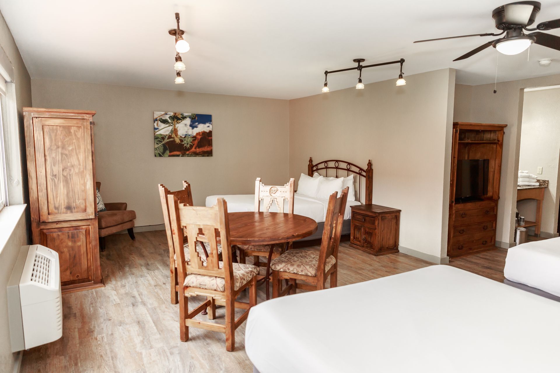 A hotel room with two beds , a table and chairs.