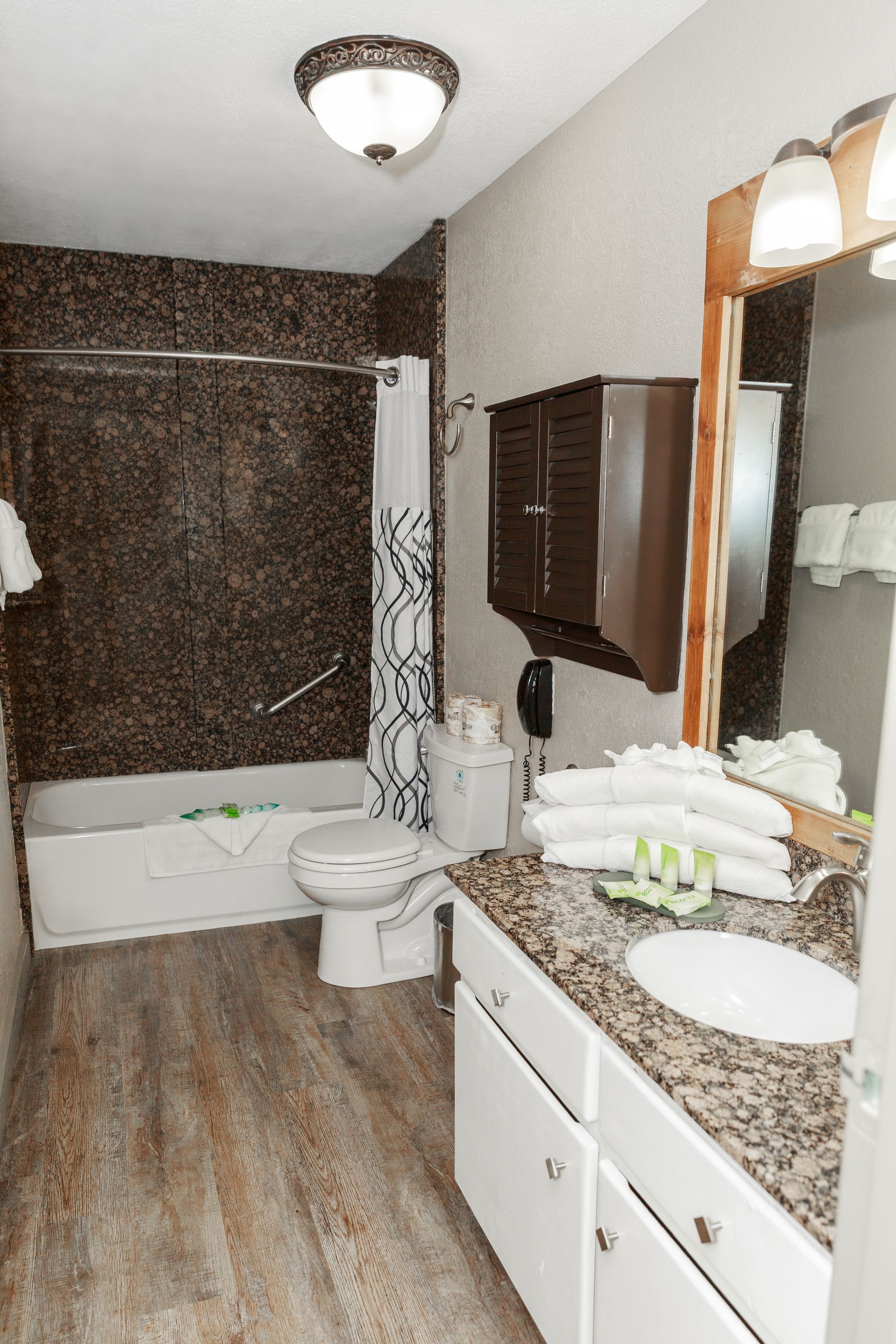 A bathroom with a sink , toilet , tub and mirror.