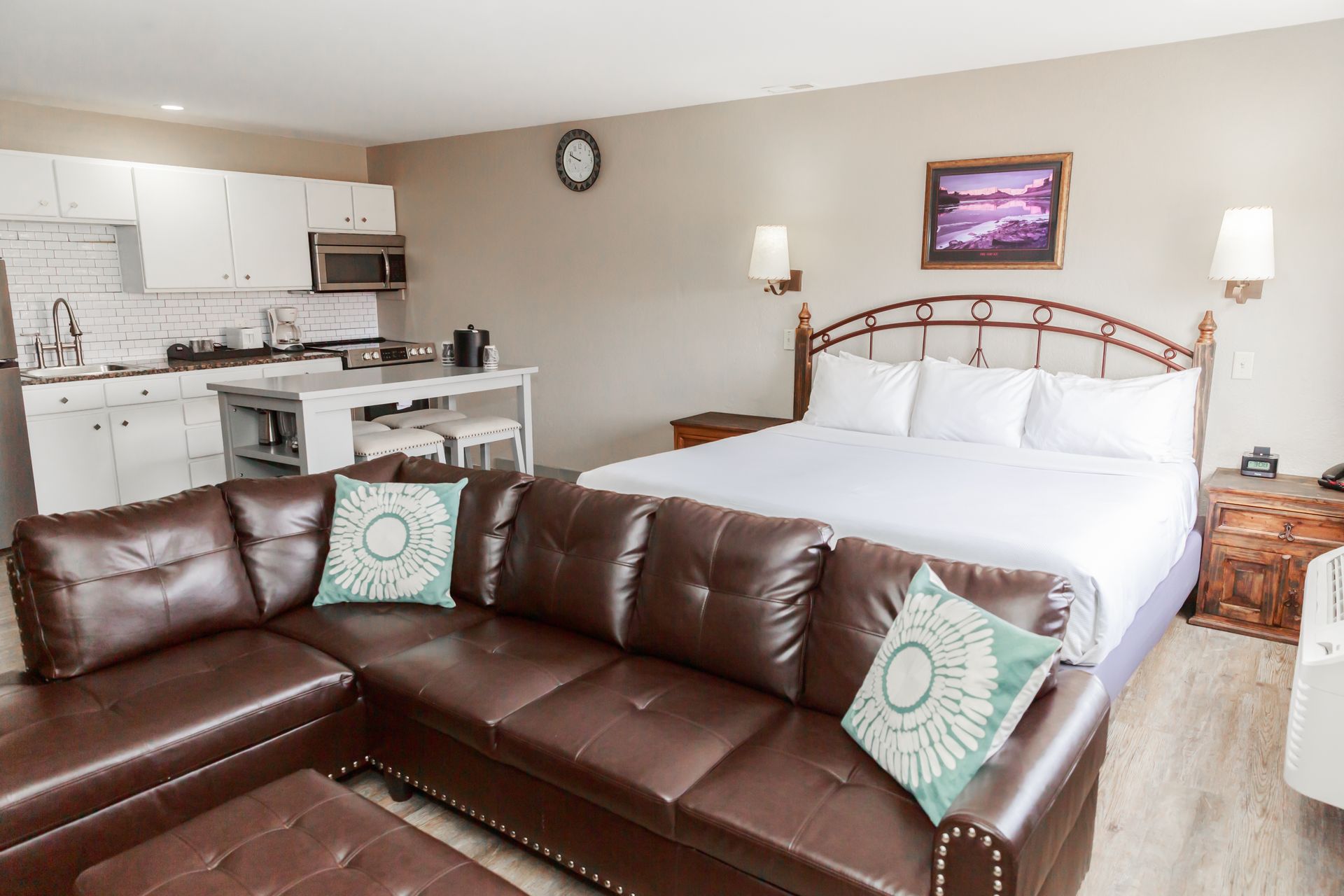 A hotel room with a couch , bed , and kitchen.