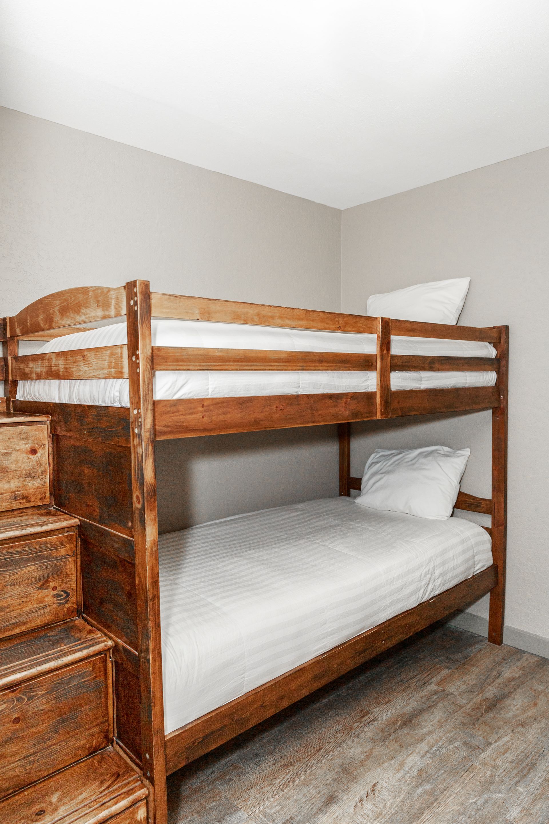 A bunk bed with stairs leading up to it in a bedroom.
