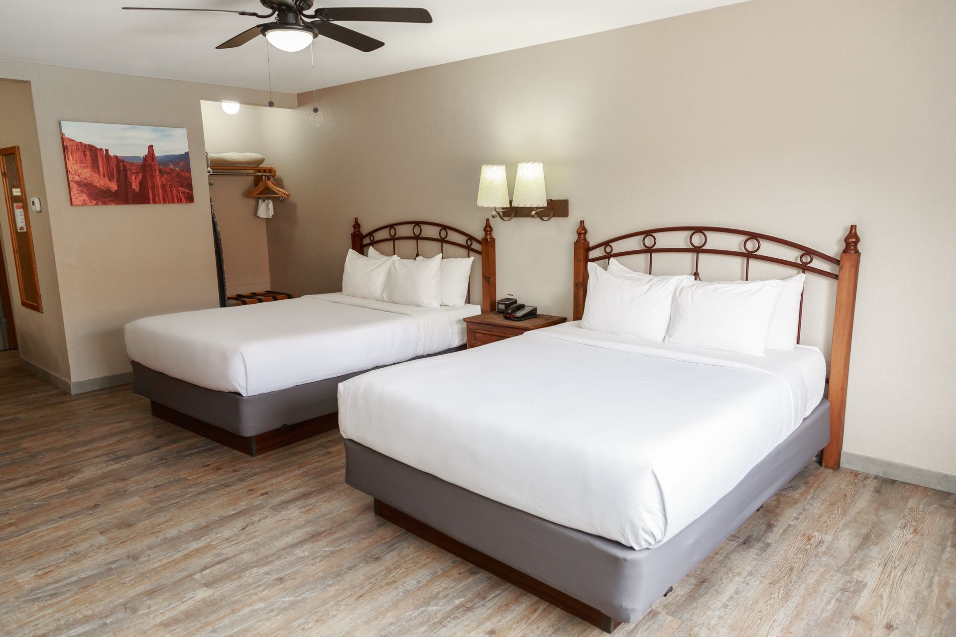 A hotel room with two beds and a ceiling fan.
