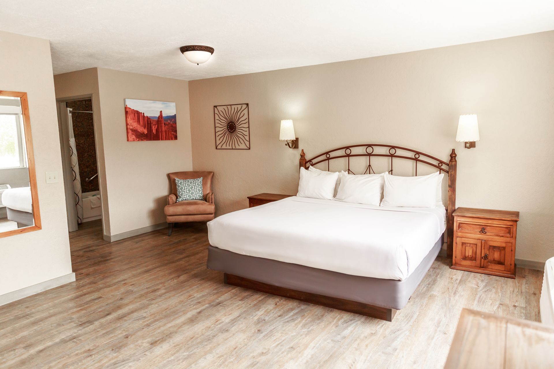 A hotel room with a king size bed and a chair.