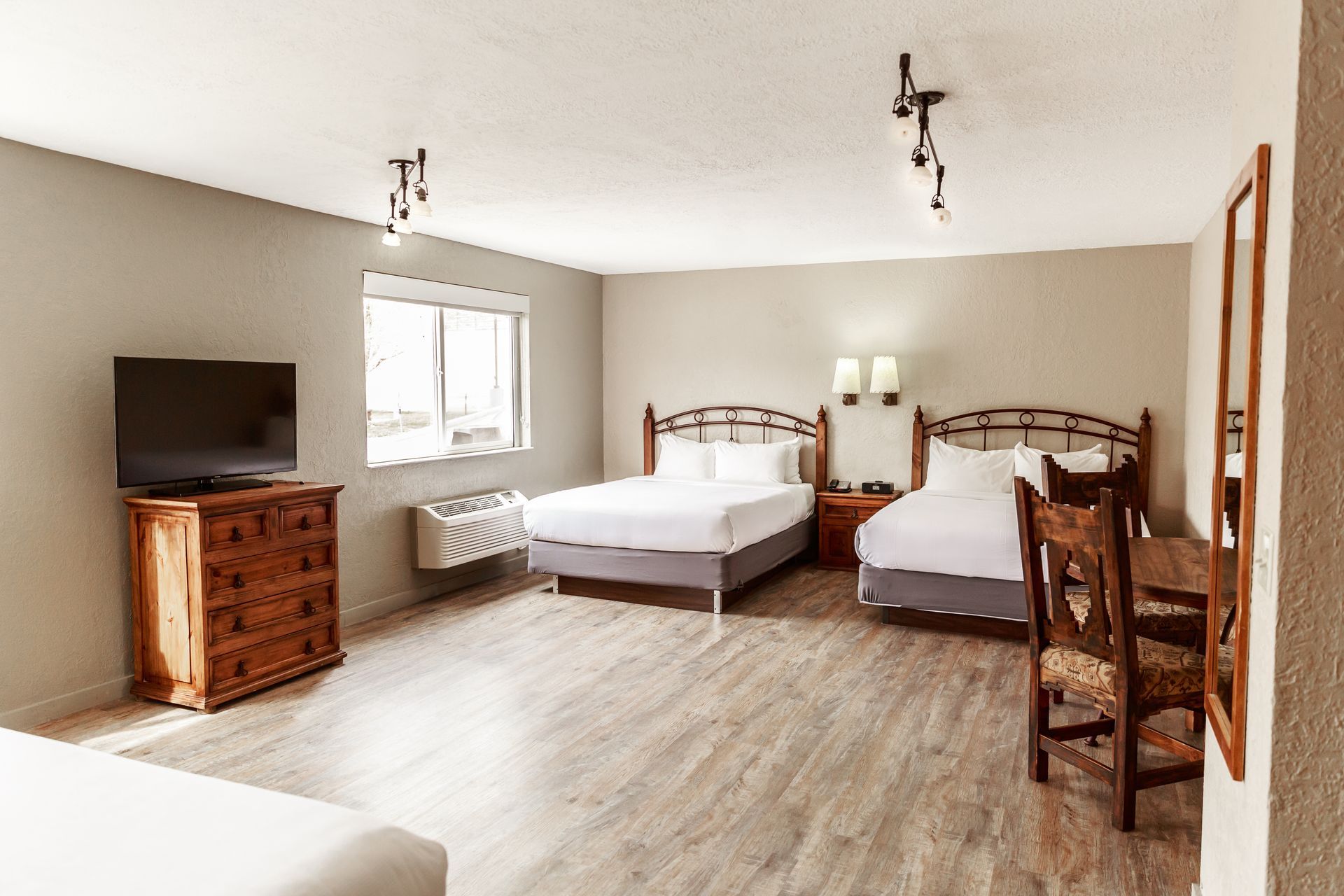 A hotel room with two beds and a flat screen tv.