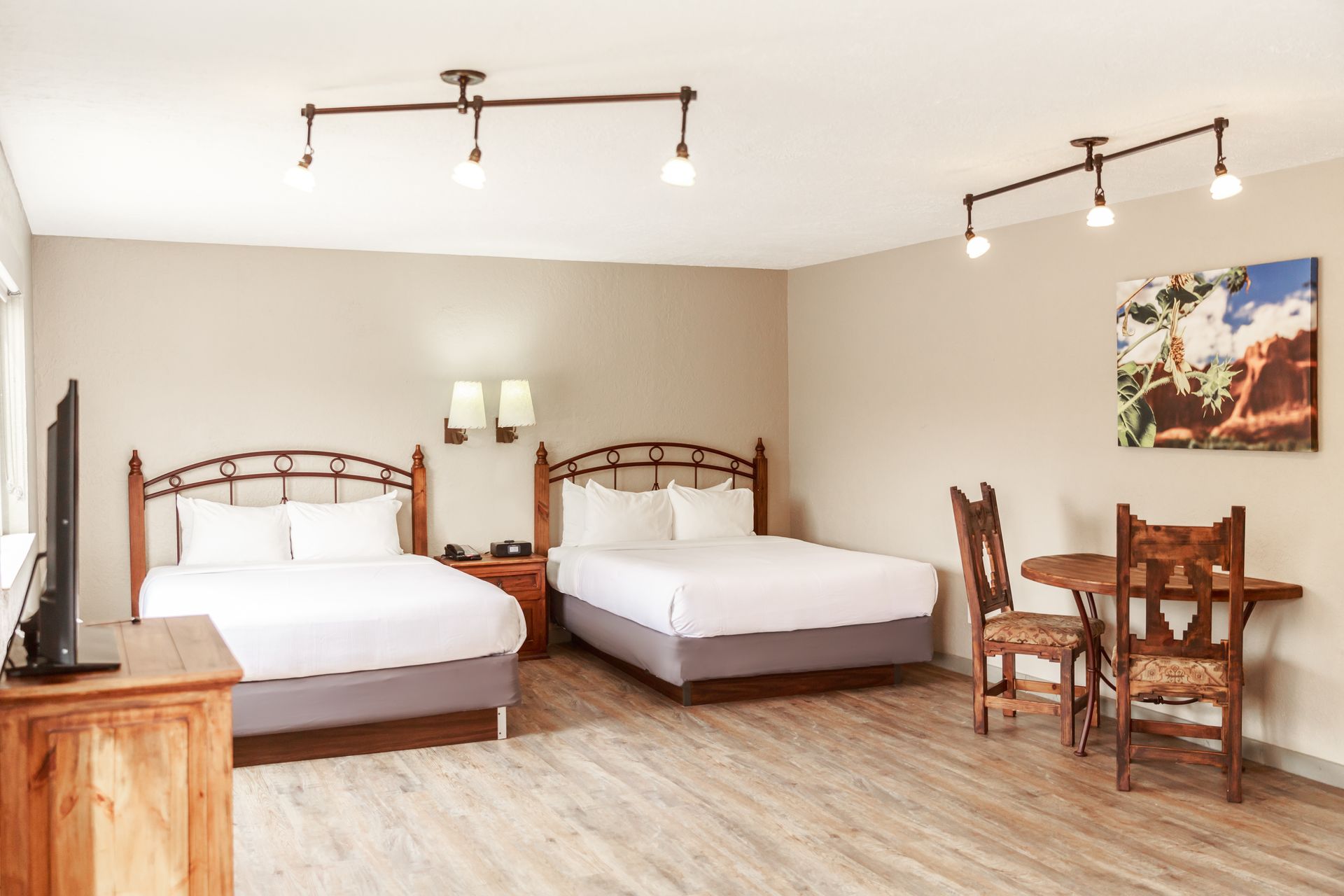 A hotel room with two beds , a table and chairs.