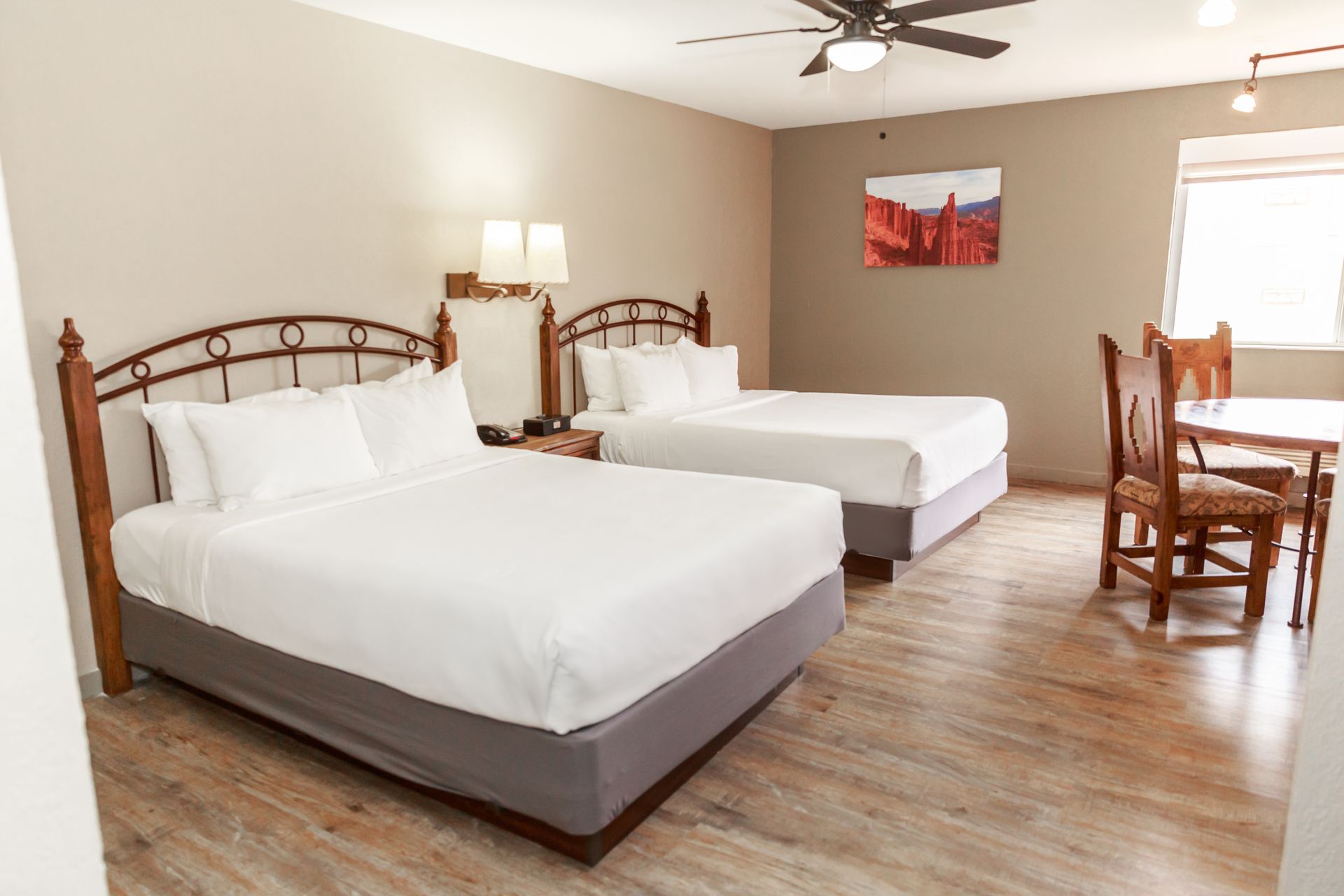 A hotel room with two beds , a table and chairs.