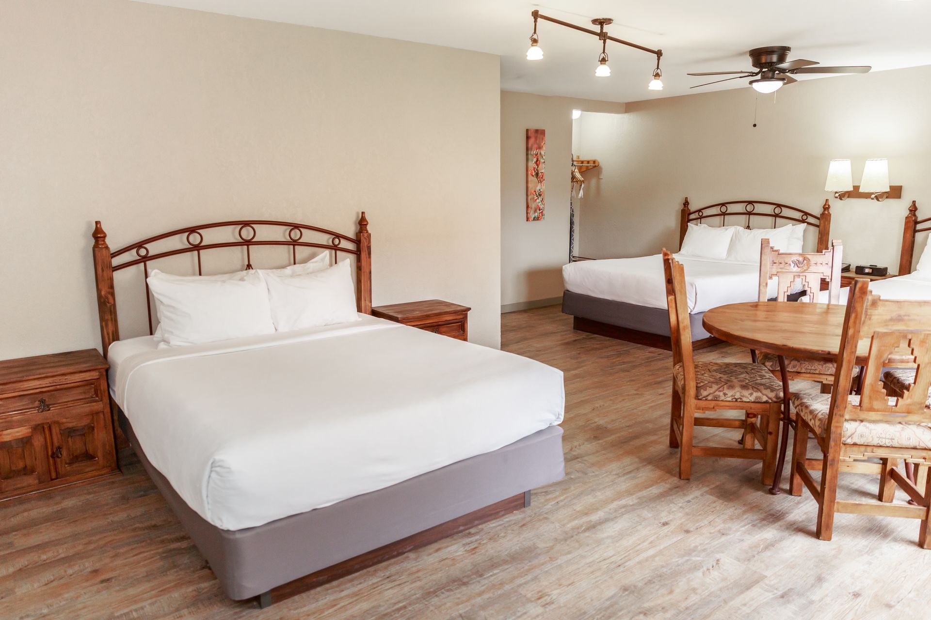 A hotel room with two beds , a table and chairs.