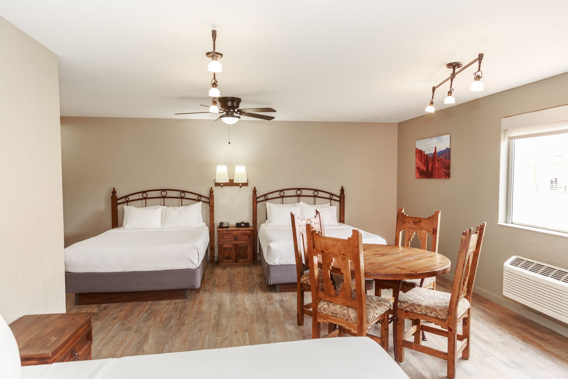 A hotel room with two beds , a table and chairs.