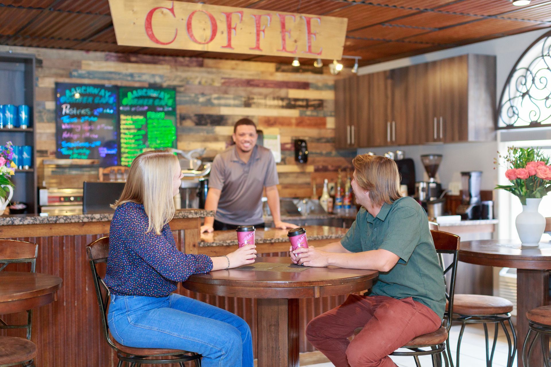 A man and two women are sitting at a table in a coffee shop.