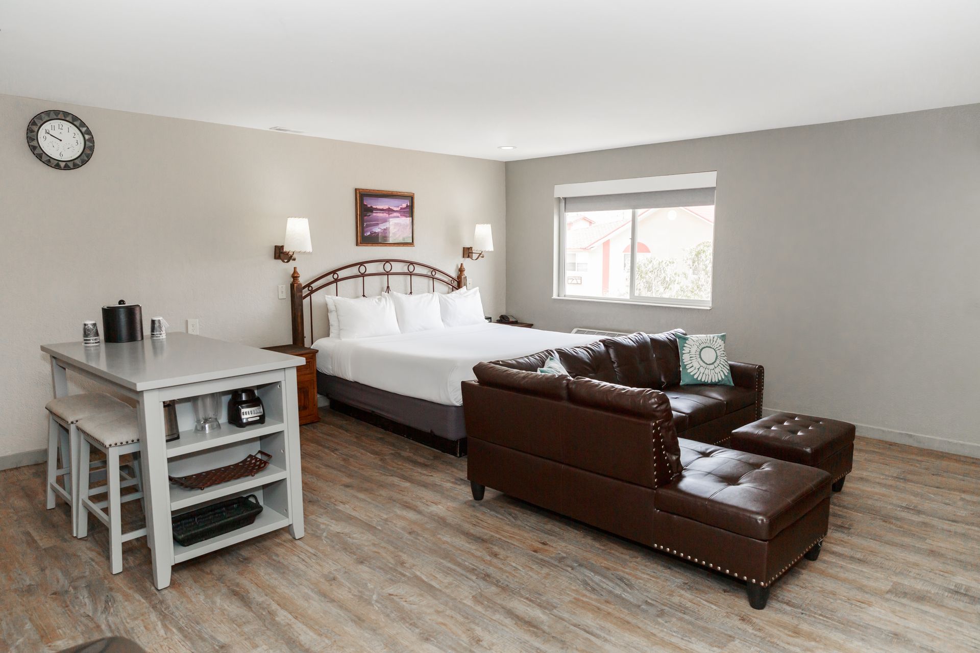 A hotel room with a king size bed , couch , table and chairs.