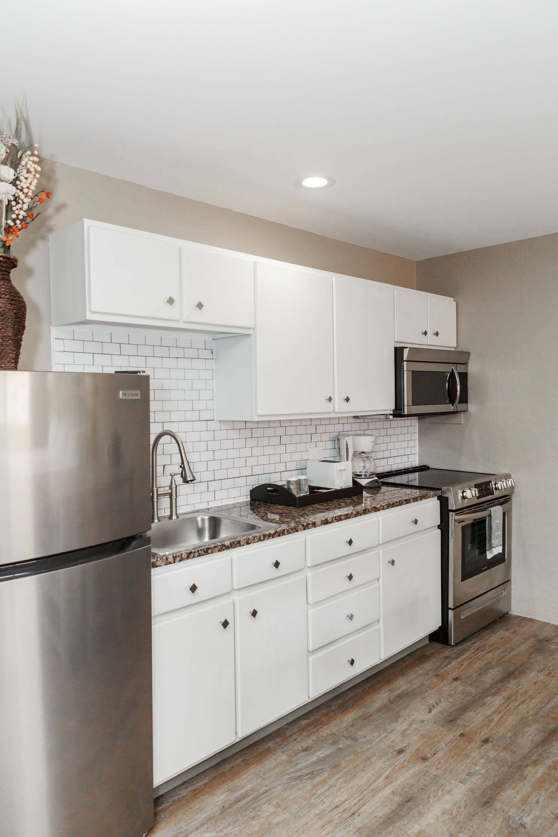A kitchen with white cabinets and stainless steel appliances.