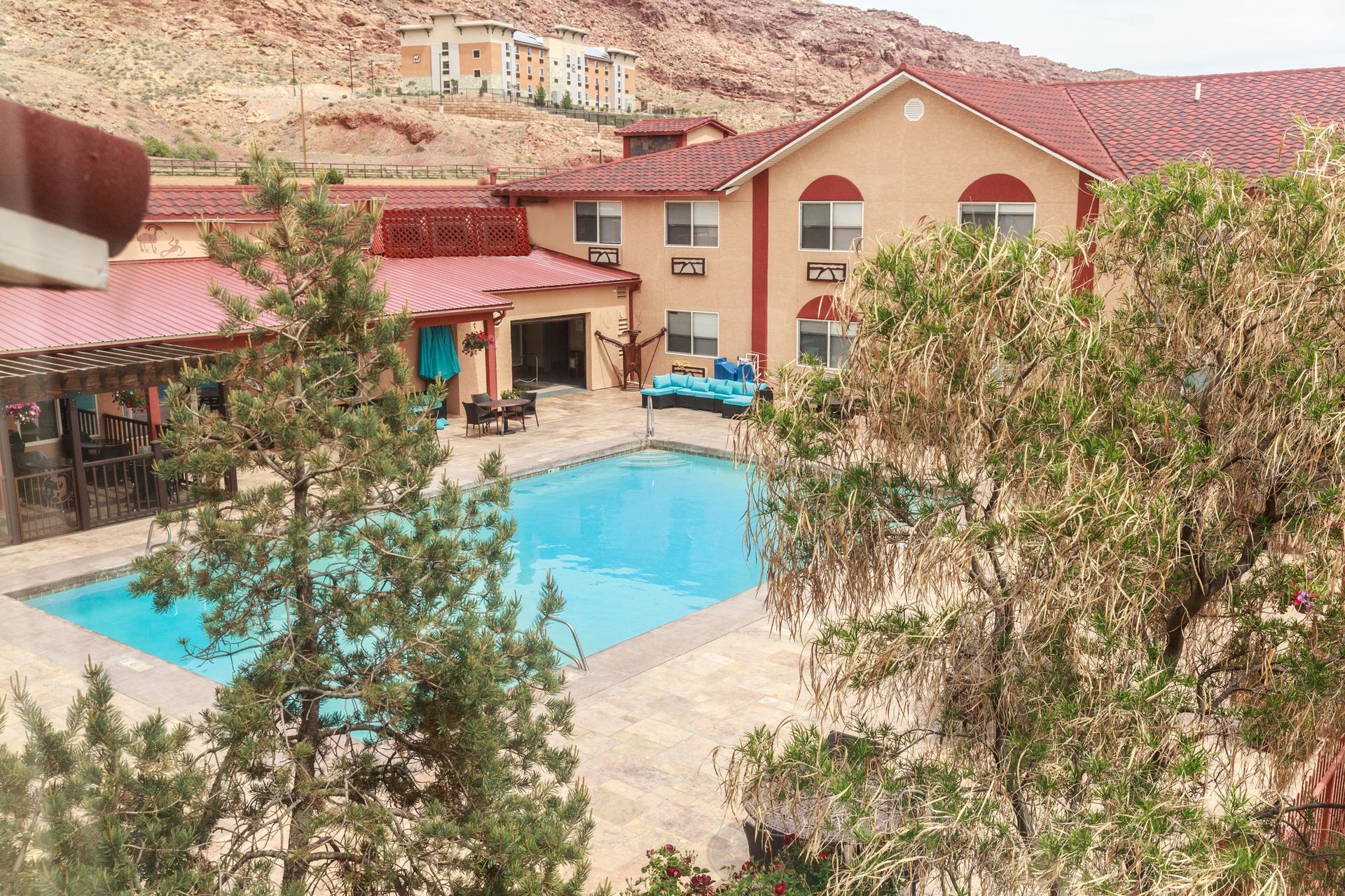 An aerial view of a hotel with a large swimming pool