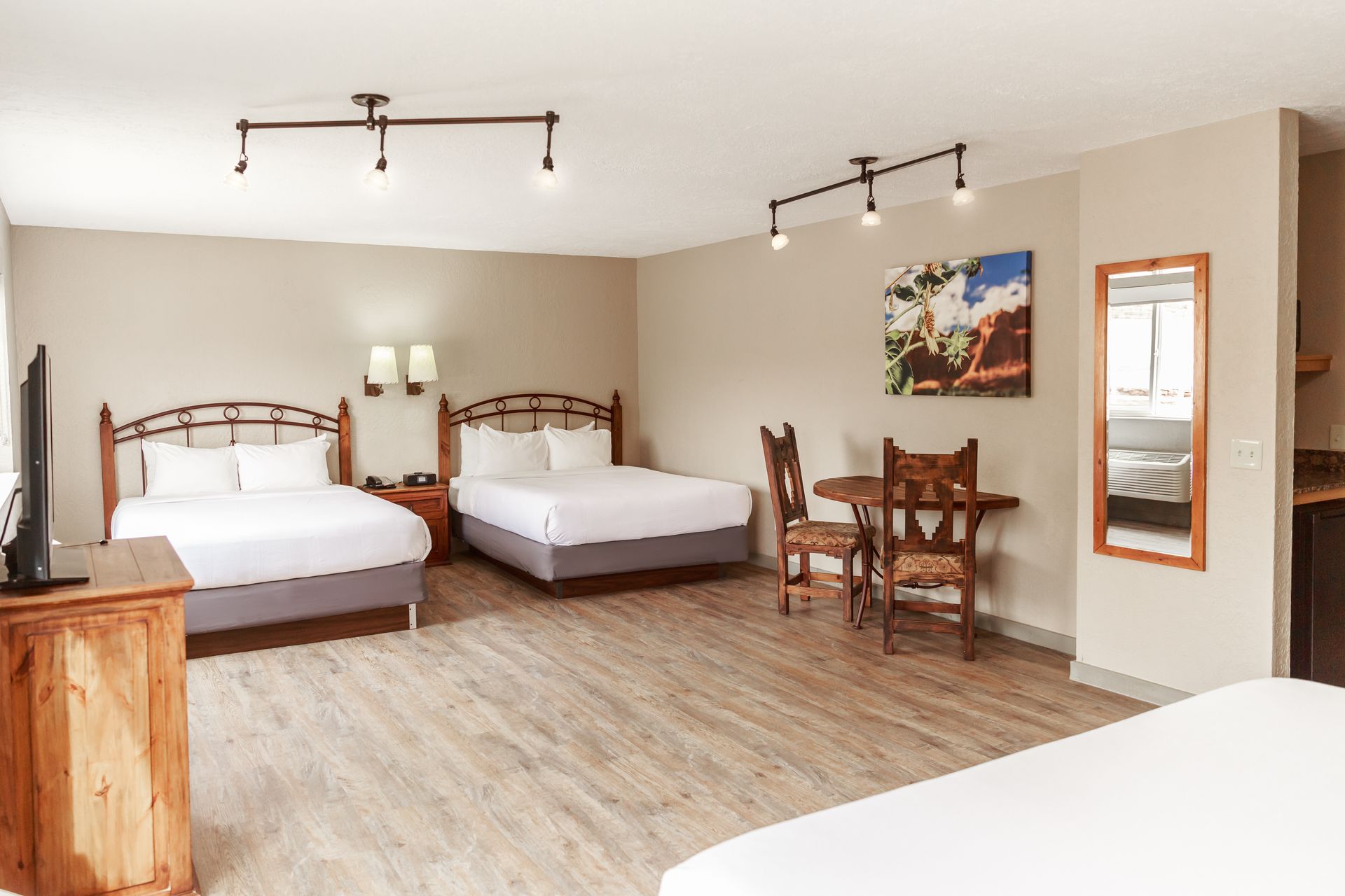 A hotel room with two beds , a table and chairs.