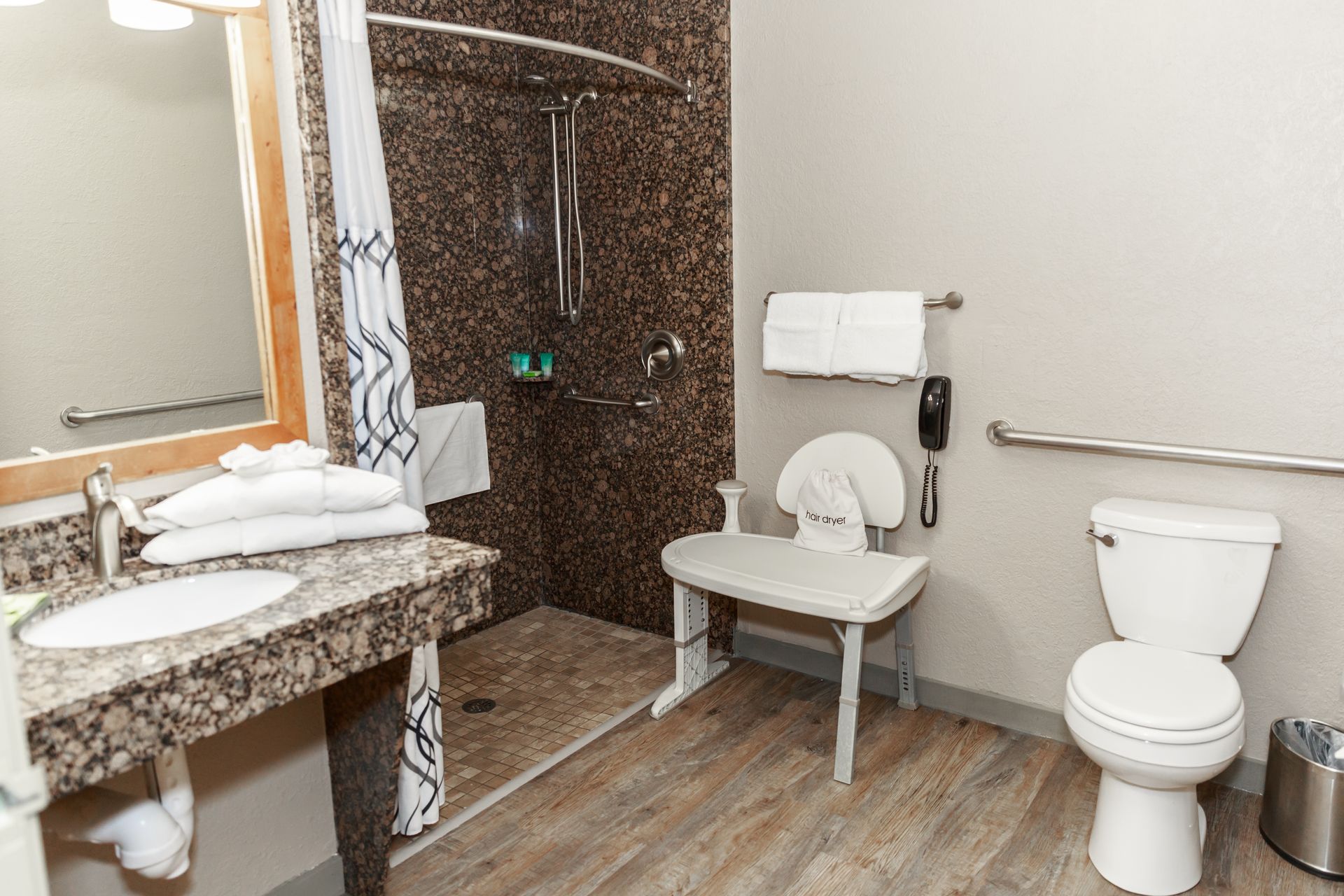 A bathroom with a toilet , sink and walk in shower.
