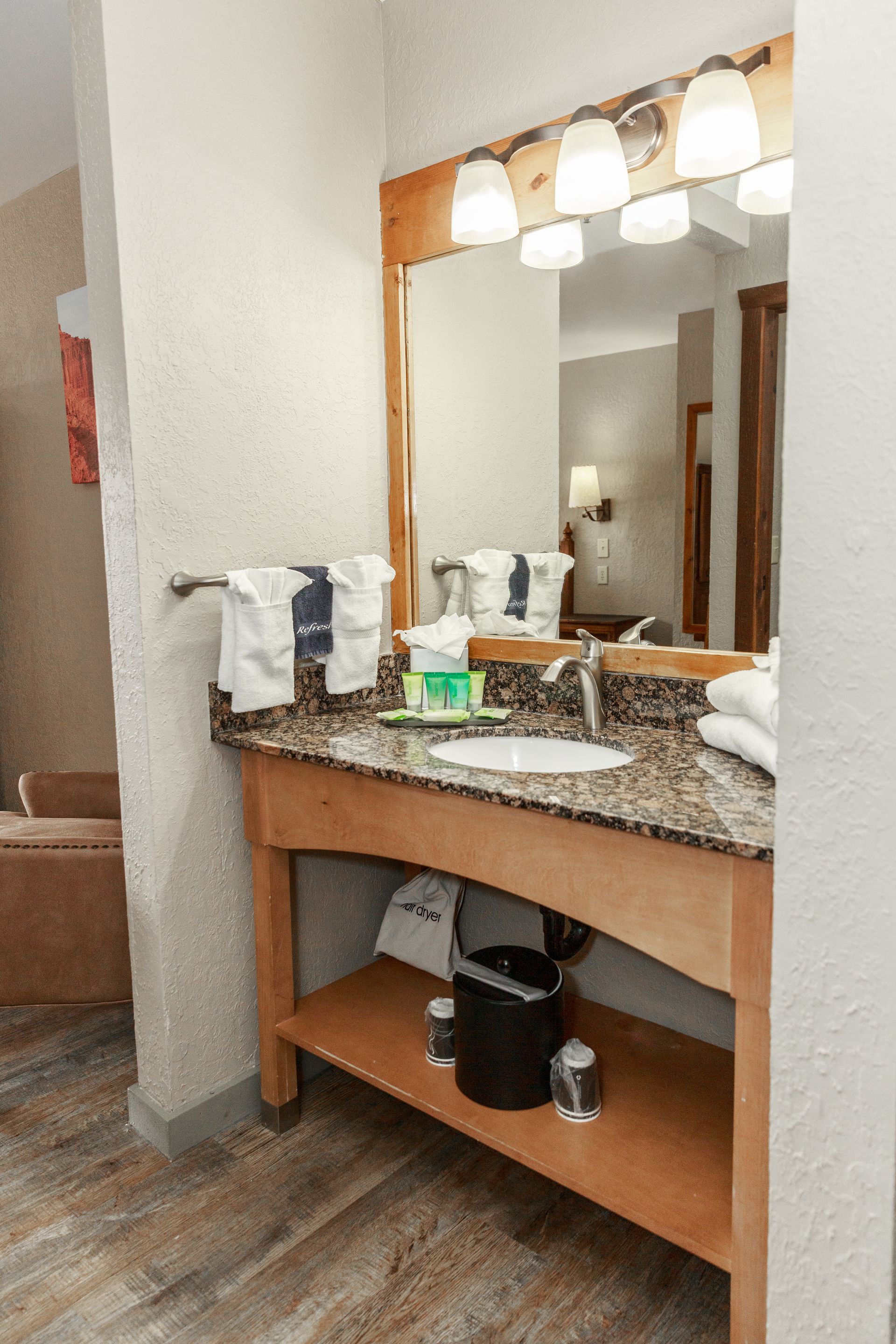 A bathroom in a hotel room with a sink and a mirror.