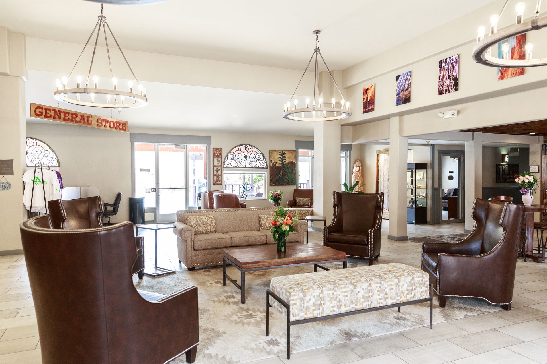 A hotel lobby with a couch , chairs , coffee table and chandeliers.