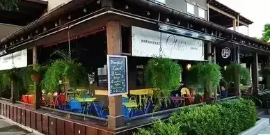 A restaurant with tables and chairs outside of it.