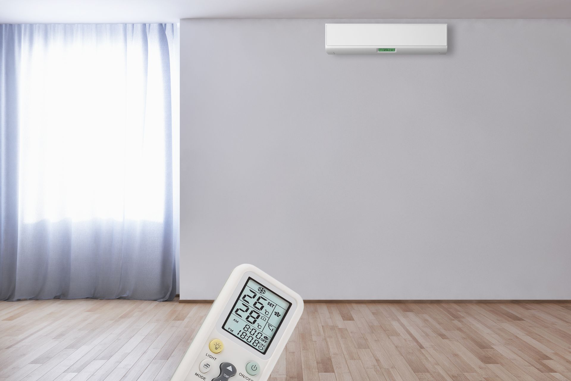 A remote control is sitting in an empty room next to a window.