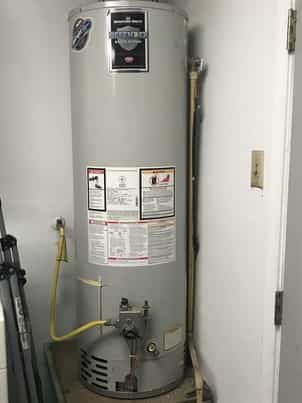 Hot water heater appliance in need or repair in garage at Waco Tx home