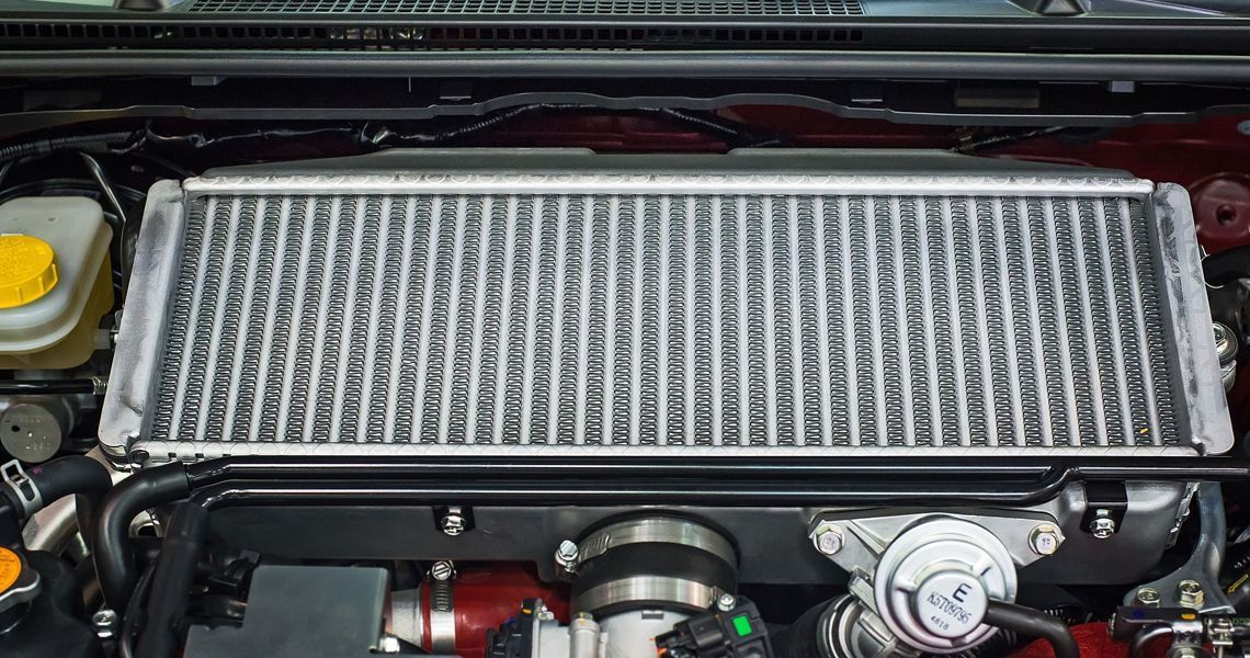 A close up of a radiator in the engine of a car.