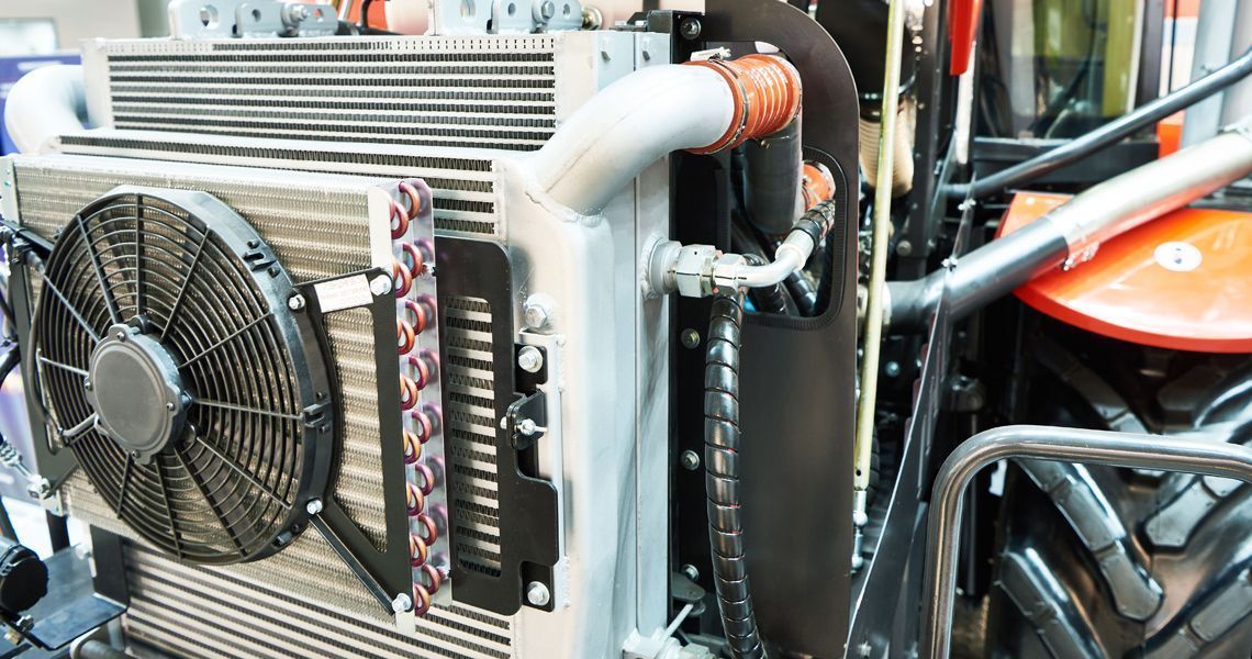 A close up of a radiator and fan on a tractor.