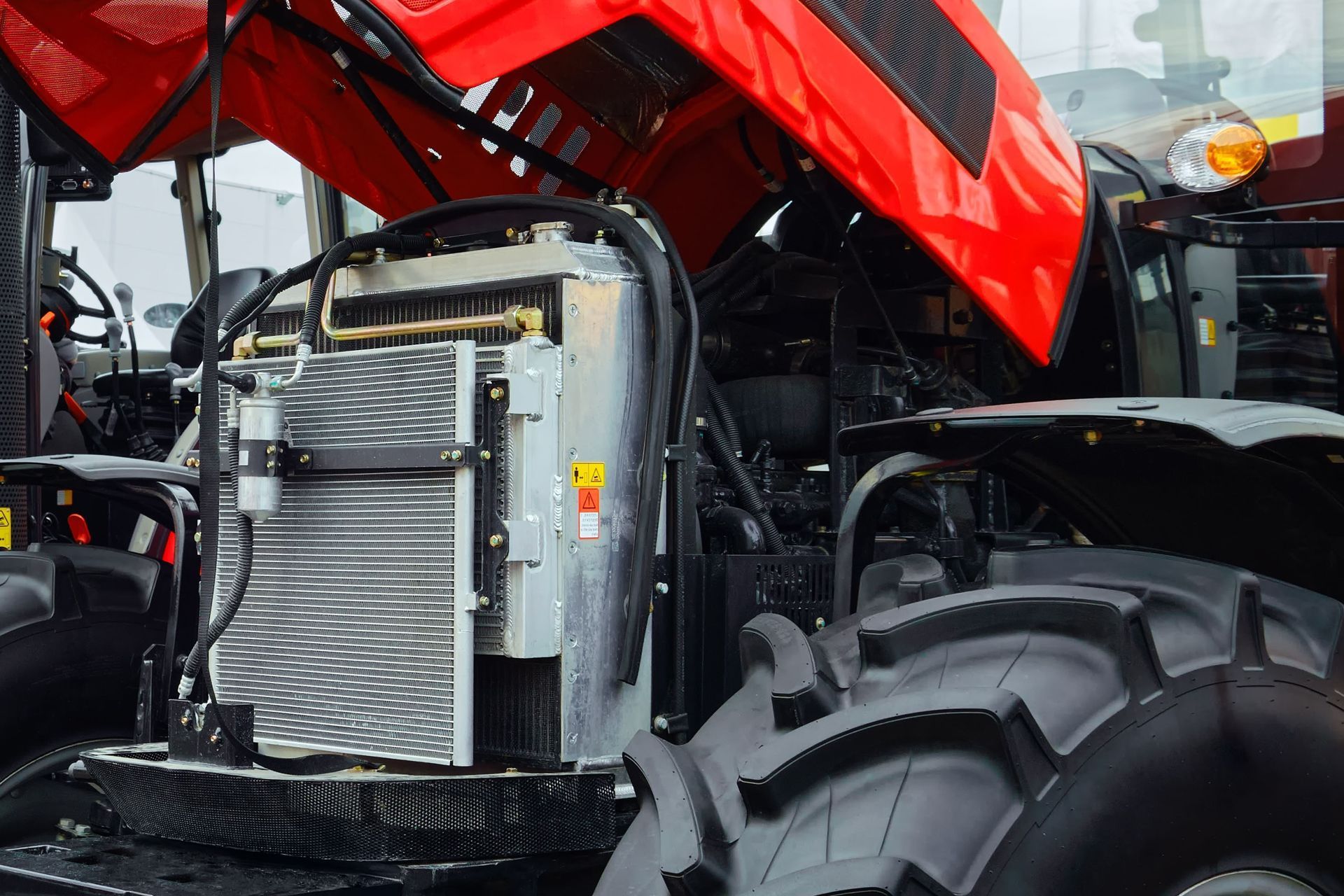 A red tractor with its hood open and radiator visible