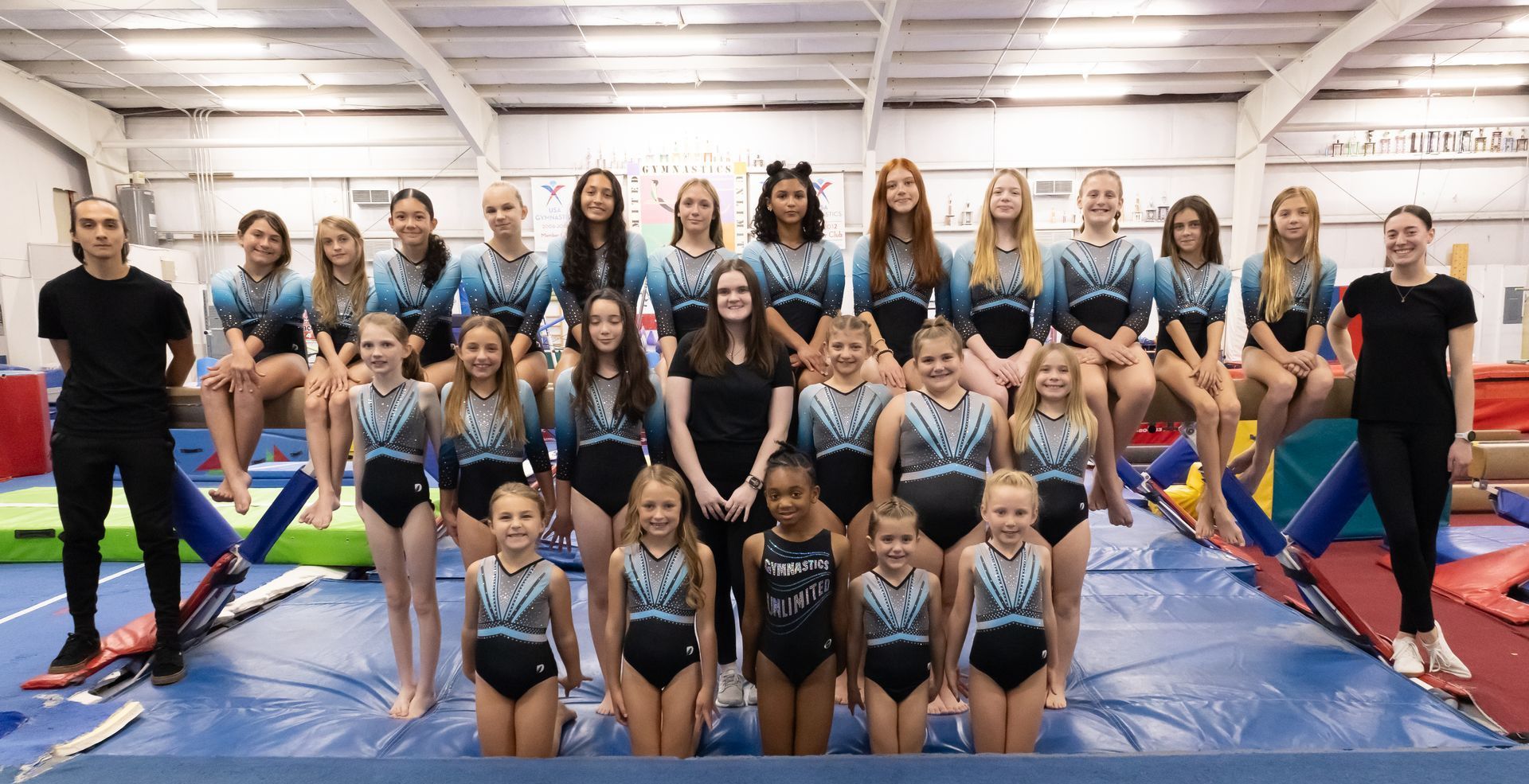 A group of young girls are posing for a picture in a gym.