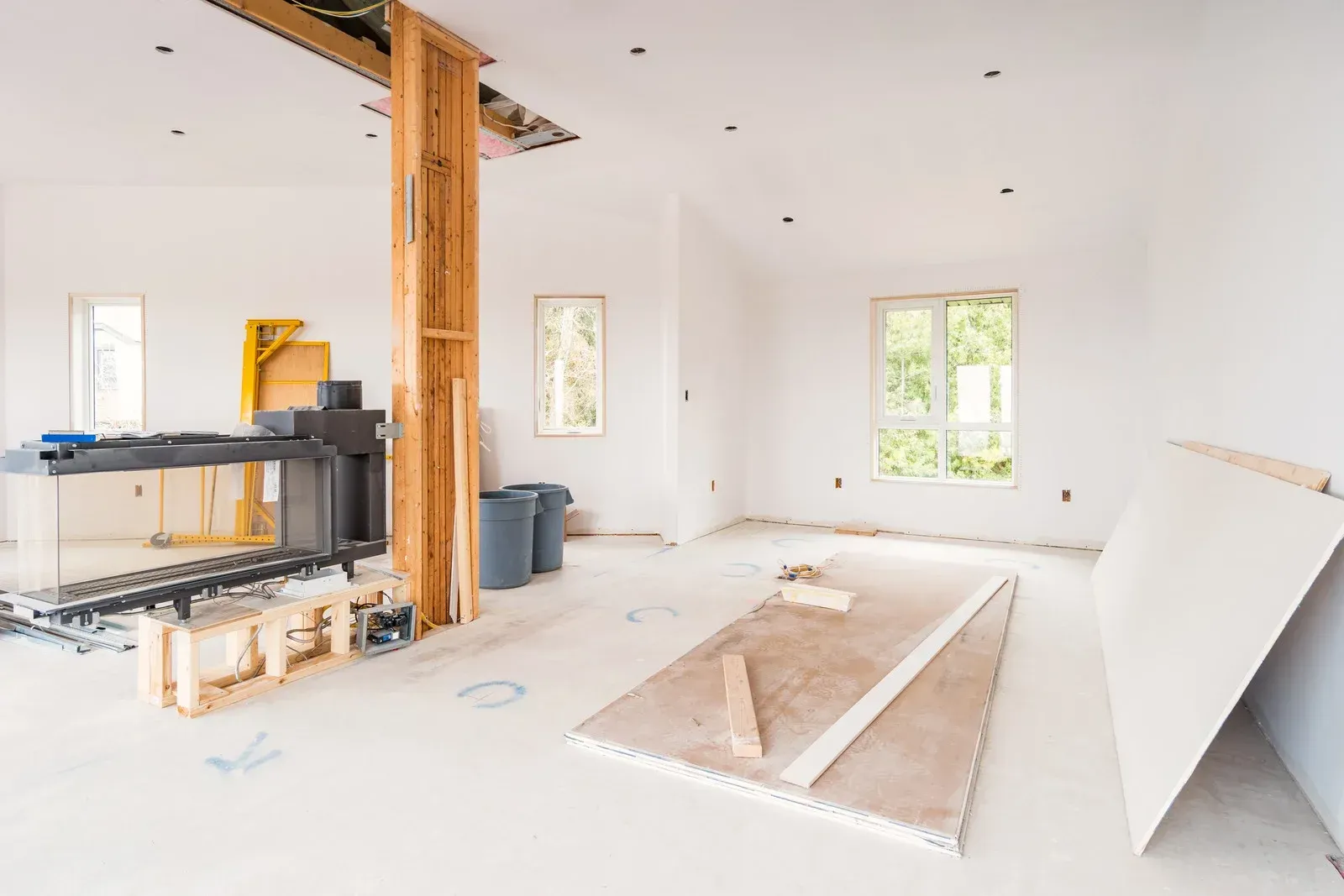 A living room in a house under construction with a fireplace.